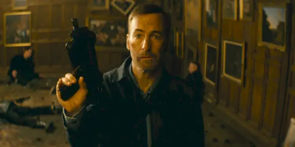 Bob Odenkirk som Hutch Mansell holder en maskinpistol i Nobody.