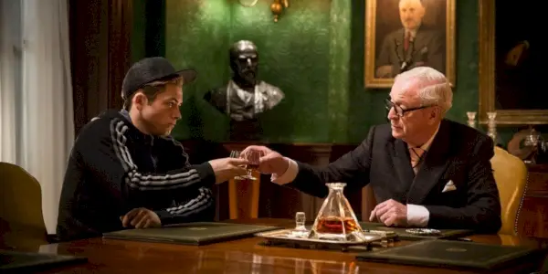 Arthur snakker med Eggsy i Kingsman.