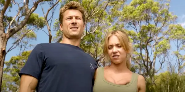 Glen Powell og Sydney Sweeney med armene om hinanden bakker i Anyone but You