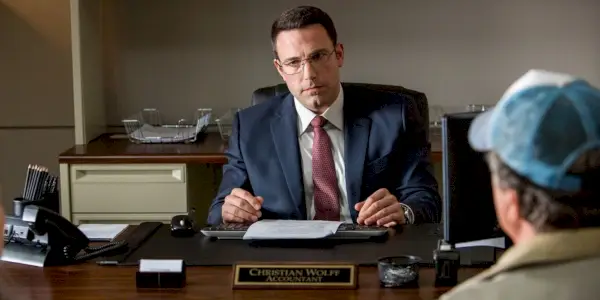 Ben Affleck ako Christian Wolff sediaci pri stole v The Accountant