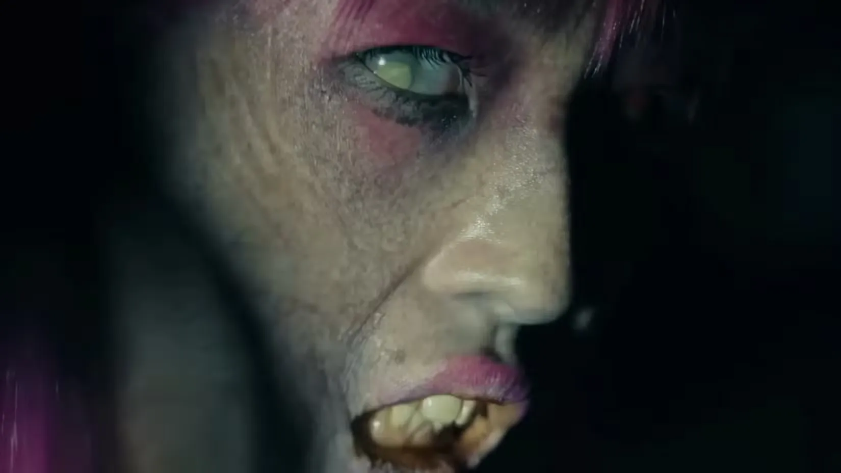 Зомби с розовыми волосами, смотрящий в камеру крупным планом в фильме 