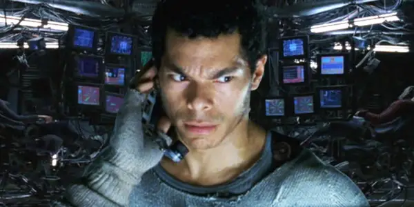 Tank in Zion in the Matrix wearing grey woollen gloves and a grey sweater.