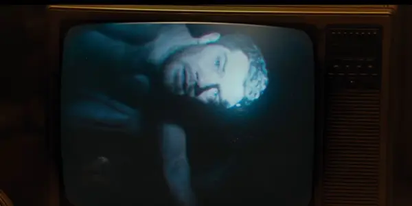 Alistair Brammer as John in The Watchers on a tv screen