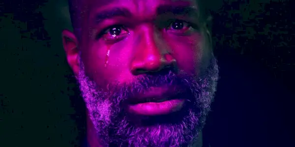 Tunde Adebimpe בוכה בעודו רחוץ באור סגול במבול
