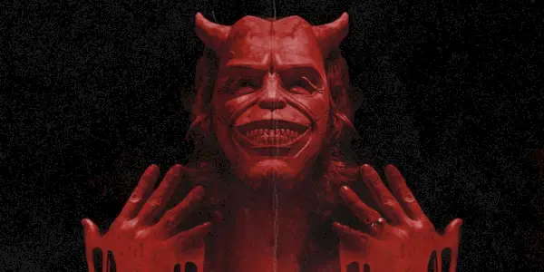 The Grabber cubierto de sangre con las manos cerca de la cara en una imagen promocional de The Black Phone
