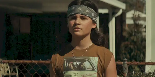 Robin se encuentra en la acera mirando The Black Phone.