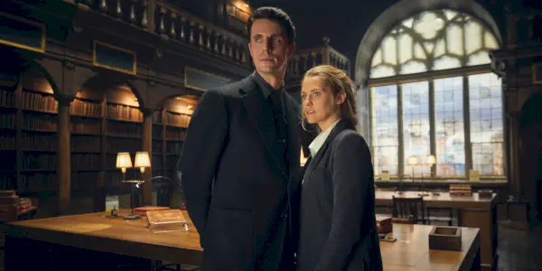 Matthew (Matthew Goode) e Diana (Teresa Palmer) em uma biblioteca em A Discovery of Witches em A Discovery of Witches