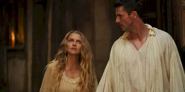 Matthew (Matthew Goode) e Diana (Teresa Palmer) em um corredor escuro em A Discovery of Witches in A Discovery of Witches