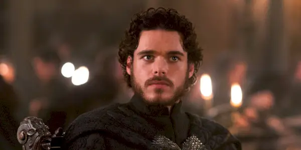 Robb Stark schaut in „Game of Thrones“ aufmerksam in einen Raum voller Menschen.