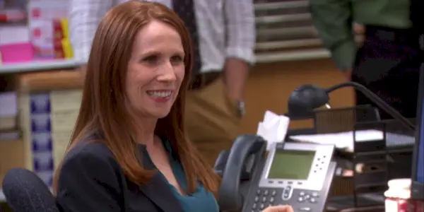 Nellie souriant à son bureau sur The Office