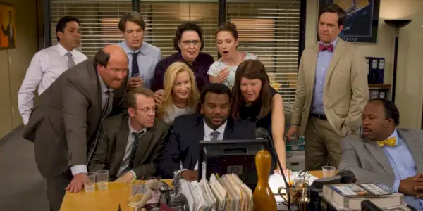 Les acteurs de The Office se tiennent ensemble et regardent un ordinateur dans The Office