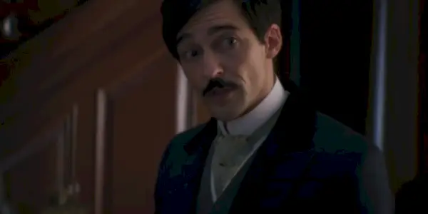 Oscar con baffi e abito in The Gilded Age